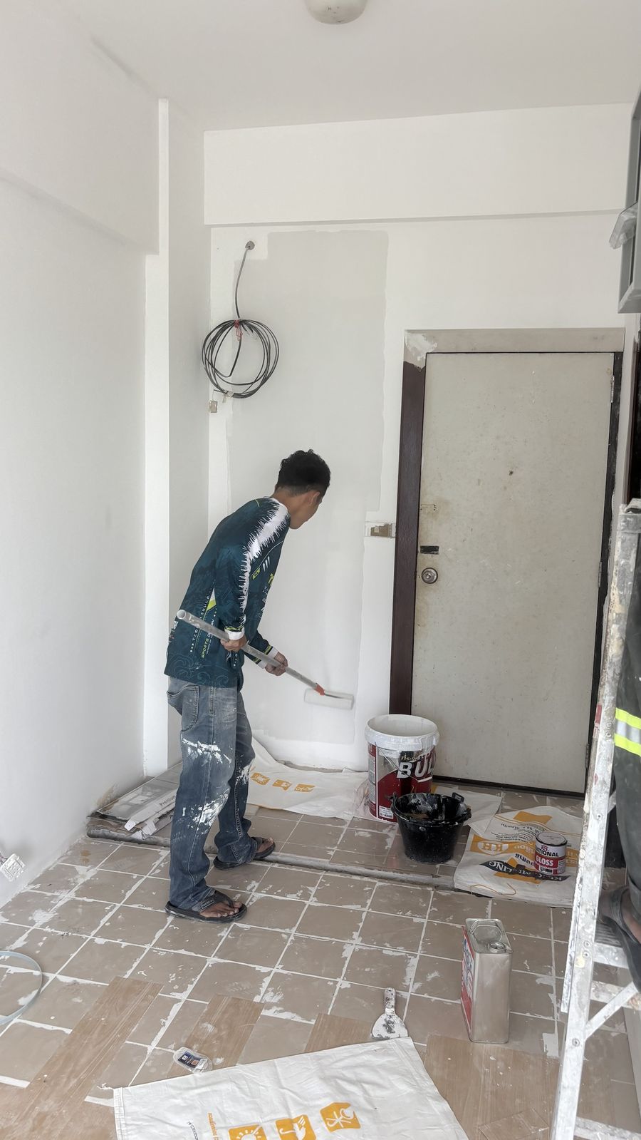 Repainting the entrance wall with a roller at Chain Condominium, unit 813, Jomtien