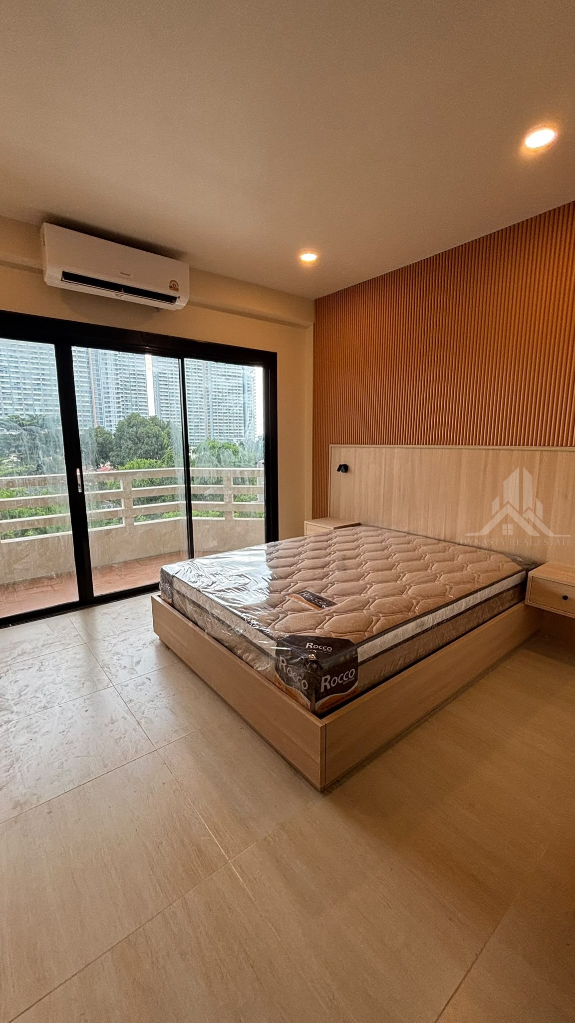 Renovated studio with built-in bed, fluted feature wall and black sliding balcony door at Chain Condo, Jomtien