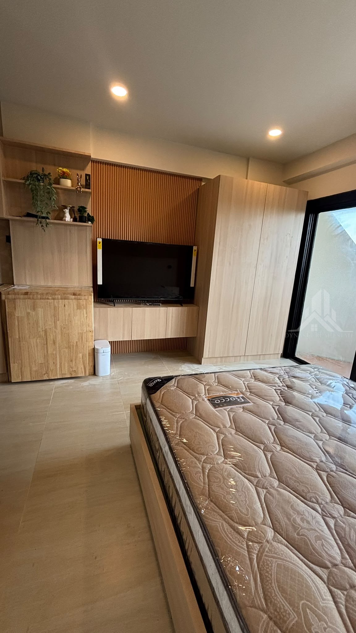 Floating TV cabinet on a fluted wall, open shelves and tall built-in wardrobe at Chain Condo, Jomtien