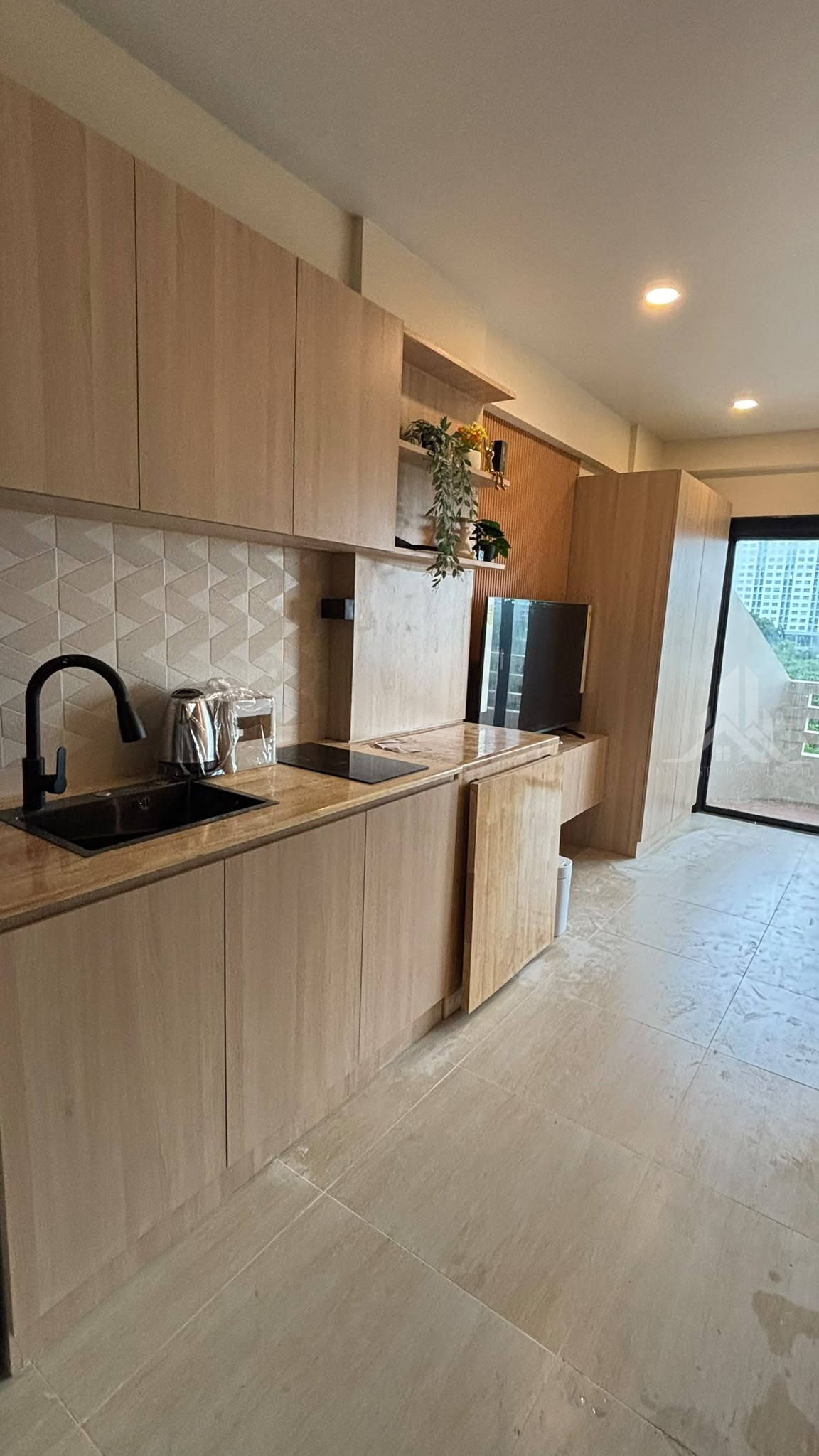 Completed built-in wood kitchen with black sink, induction hob and 3D tile backsplash at Chain Condo, Jomtien