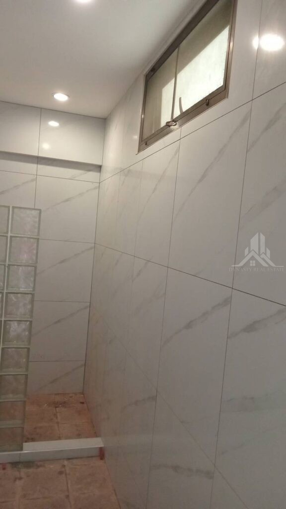 Bathroom walls finished in large-format marble-look tiles at Sunrise Condo, Pattaya