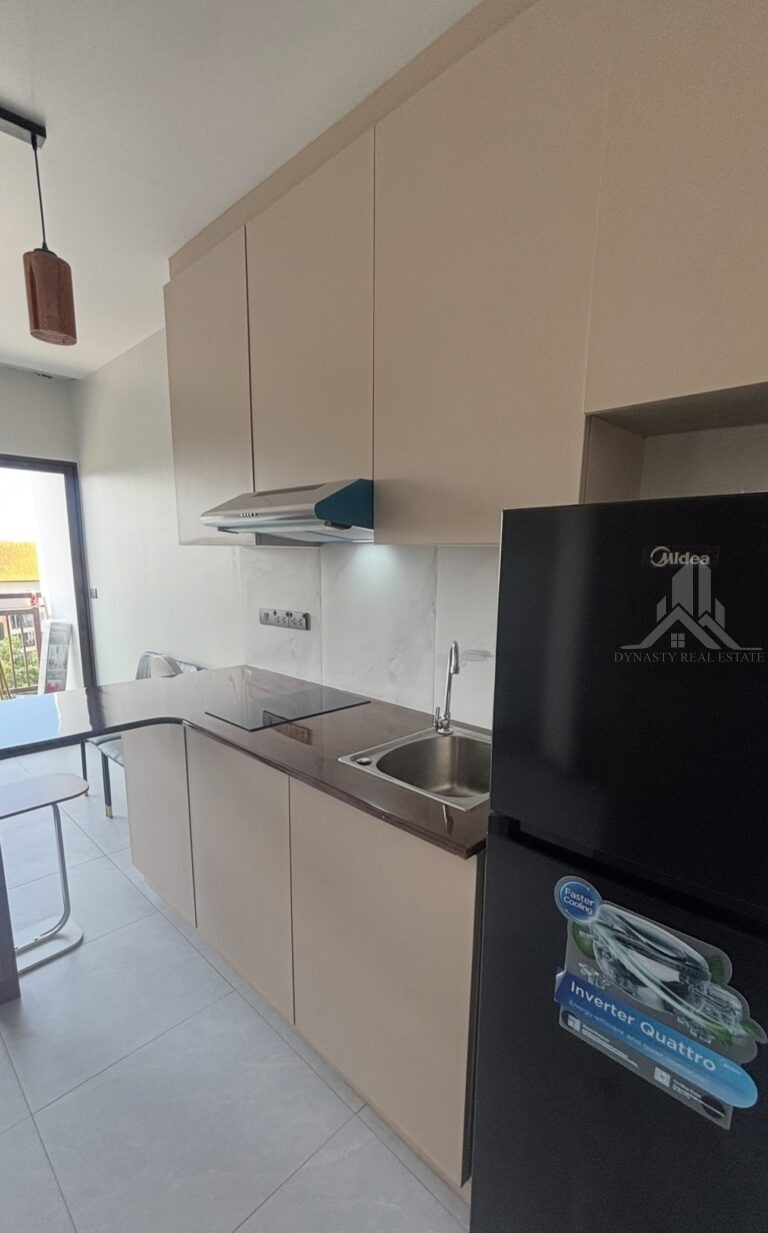 Upper and lower built-in kitchen cabinets with hood, sink and marble-look backsplash in a Treetops Pattaya condo