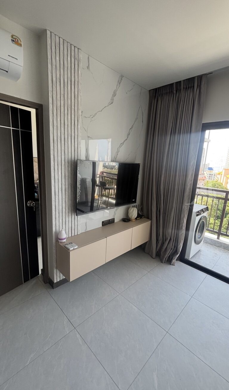 Treetops Pattaya condo living room with floating TV cabinet and marble-look feature wall